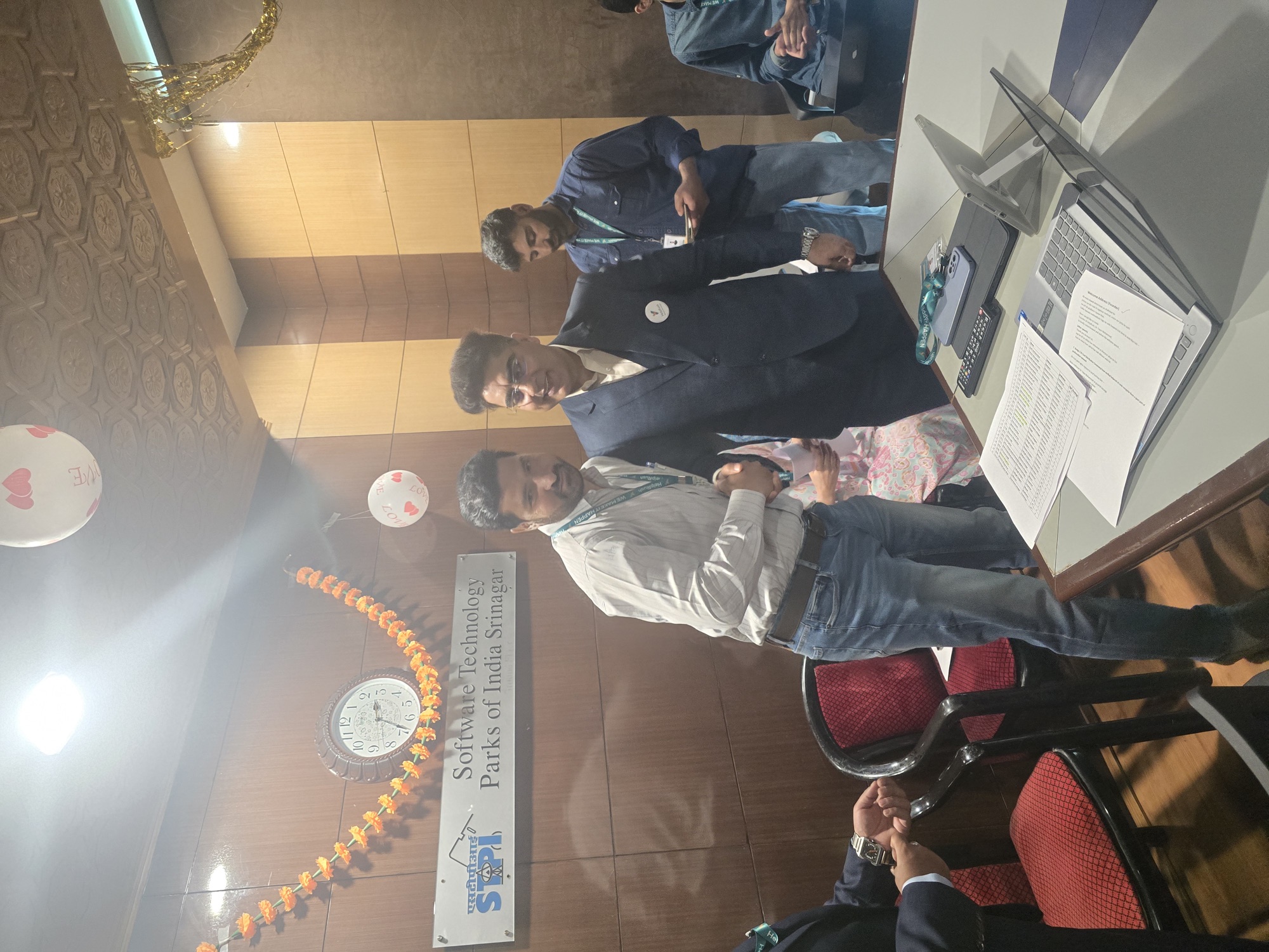 Dr. Fayyaz Muhammad with a senior dignitary at the Founding Partners Ceremony, with the official Software Technology Parks of India Srinagar signage and a marigold garland visible in the foreground.