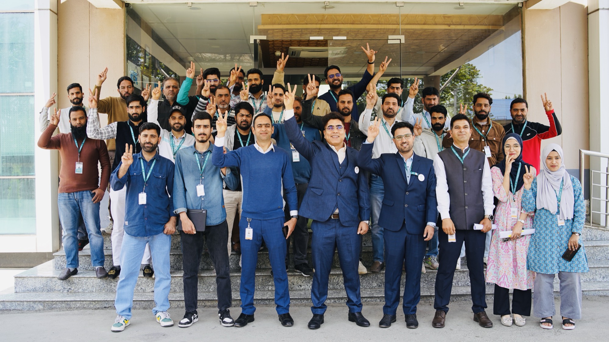Forty service pros and the HelpRush team gathered on the steps of the company's Rangreth office in Srinagar, hands raised in a victory sign during the HelpRush Assured first-batch ceremony.